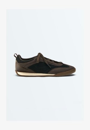 Baskets marron et noires avec panneaux latéraux en mesh, fermeture à lacets à l'avant, semelle beige profil bas et languette au talon, vues de profil droit.
