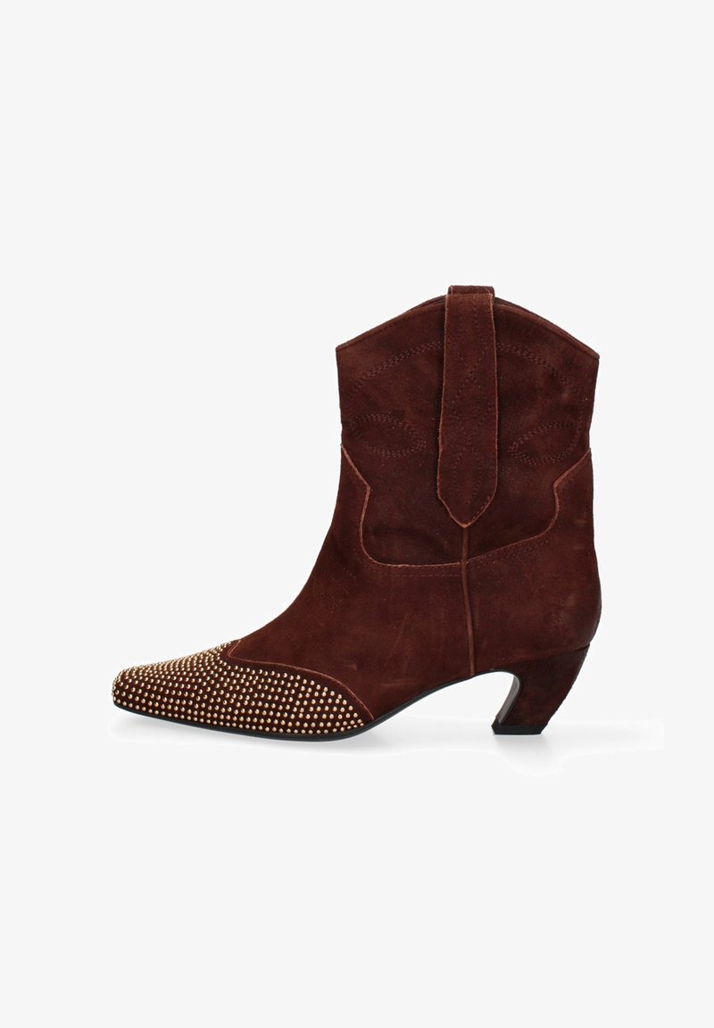 Stivale da cowboy in suede marrone con punta affilata, abbellito da borchie dorate sul davanti, con tacco basso e cuciture decorative.