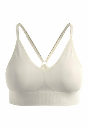 Brassière de sport couleur crème, sans coutures, avec fines bretelles réglables croisées dans le dos et une large bande de soutien en dessous.