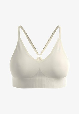 Brassière de sport couleur crème, sans coutures, avec fines bretelles réglables croisées dans le dos et une large bande de soutien en dessous.