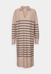 Béžové pletené šaty s výstřihem do V a límcem. Obsahují tmavé horizontální pruhy a dlouhé rukávy. Měkká textura, volný střih.