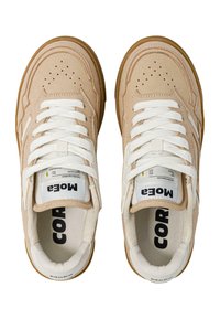 Beżowe zamszowe sneakersy z białymi sznurówkami, z teksturowanym wierzchem, wyściełanym kołnierzem i brązową gumową podeszwą. Widoczna etykieta marki wewnątrz.