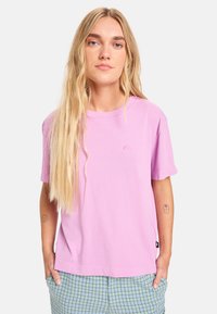 Φωτεινό ροζ βαμβακερό t-shirt με κοντά μανίκια και άνετη εφαρμογή. Διαθέτει μικρό λογότυπο στο στήθος και πλαϊνή ετικέτα.