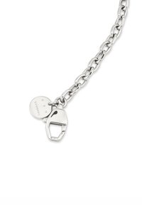 Zilveren schakelarmband met een karabijnhaak en een ronde hanger gegraveerd met letters op een witte achtergrond.