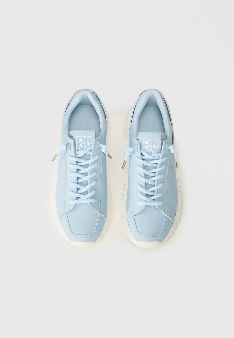 Sneaker DKNY azzurro chiaro con suole e lacci bianchi spessi, visti dall'alto su uno sfondo bianco semplice.