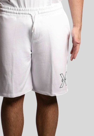 Pantaloni sportivi bianchi in cotone con vita elasticizzata e cordoncino. Presentano una stampa nera del logo sulla coscia sinistra. Texture liscia.