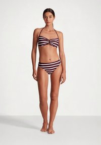 Stripete bikinisett i burgunder og hvitt, med en bandeautopp med sentralt gullaktig detalj og tilhørende høytlivsbukser. Mykt stoff.