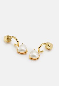 Gold-tone earrings with heart-shaped white faux pearls, featuring a hoop design and post backing. Smooth texture and polished finish.