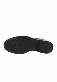 Suola di scarpa nera con una finitura liscia, caratterizzata da motivi di trazione circolari e un bordo piatto, realizzata in materiale gommoso per garantire durata.