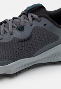 Grijze sportshoe met bovenwerk van mesh, textuuraccenten en teal veters. Beschikt over een cushioned zool met een gemêleerd profiel.