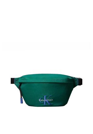 Grüne Bauchtasche mit schwarzem verstellbarem Riemen und Reißverschluss, mit blau-weißem „Calvin Klein“ Logo vorne in der Mitte.