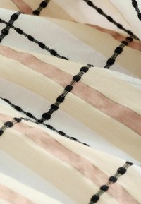 Tela impresa con franjas alternas en crema, rosa suave y negro, con acentos texturizados y finas líneas negras tejidas.