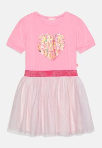 Różowa sukienka z krótkim rękawem, ozdobiona brokatowym sercem, z warstwową spódnicą z tiulu, zakończona różową taśmą z cekinami.