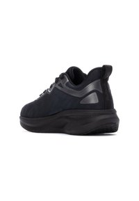 Zapatillas deportivas negras con parte superior de tejido texturizado, acentos grises en contraste, un cuello acolchado y una suela gruesa y acolchada diseñada para la comodidad.