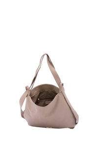 Beige leren handtas met een gladde textuur, voorzien van lange hengsels en een open bovenkant die een ruime binnenkant onthult met een ritsvak.