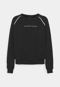 Sudadera negra de mezcla de algodón, con cuello redondo, mangas largas y dos bolsillos laterales. Texto "ARMANI EXCHANGE" mostrado.