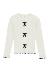 Vit långärmad topp med svarta volangärmar och tre svarta bandapplikationer fram, ribbad tyg och rund halsringning.