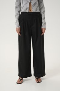 Black wide-leg trousers with pleats, featuring a smooth texture and a high waist. Paired with a grey patterned cropped top and black sandals.