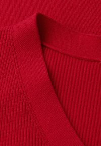 Tessuto a maglia rosso con una trama rigata, caratterizzato da un scollo a V e dettagli lisci attorno al colletto.