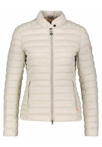 Chaqueta acolchada beige claro con diseño acolchado vertical, cuello alto, cremallera frontal y bolsillos laterales. Presenta un logo sutil en la manga.