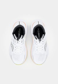Weiße Laufschuhe mit einem Mesh-Obermaterial, schwarzen und gelben Akzenten, strukturiertem Design und leuchtend orangefarbenen sowie grünen Sohlen. Die Schnürsenkel sind weiß.