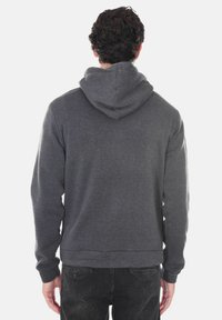 Felpa grigia con un ampio cappuccio e tasca a marsupio. Realizzata in tessuto morbido, presenta polsini e orlo a coste per una vestibilità aderente.