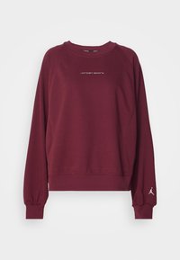 Sudadera burdeos de manga larga, con puños acanalados y cuello redondo. Presenta el logotipo "Jordan Sports" en blanco y un gráfico del logotipo en la manga.