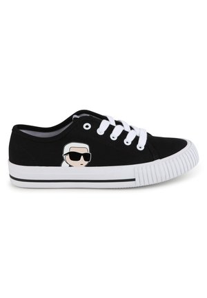 Sneaker nera in tela con accenti bianchi, caratterizzata da un volto da cartoon che indossa occhiali da sole. Punta arrotondata e suola in gomma con battistrada testurizzato.