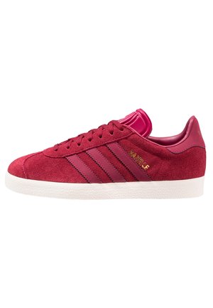 Rød ruskind Adidas Gazelle sneaker med mørkerøde striber, hvid sole og guld "Gazelle" tekst på siden, vist fra ydersiden.