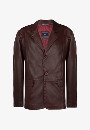 Pruun nahast pintsak, millel on sile tekstuur, nurgeline krae, kaks nuppu ja kaks esikot. Sisemus on kontrastset punast voodrit.