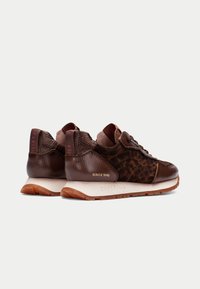 Dunkelbraune Sneaker aus strukturiertem Leder mit Leopardenmuster-Akzenten. Runde Zehenform, Schnürdesign und kontrastierende Gummisohle.