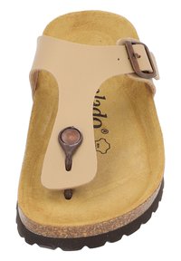 Sandalia beige con un lazo para los dedos, acento de hebilla y plantilla texturizada en marrón. La suela gruesa en marrón contrasta con el diseño superior más claro.