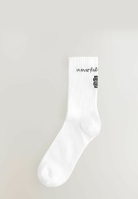 Bijela pamučna čarapa s rebrastom teksturom, koja sadrži otisnuti crni natpis "neverfull" i dekorativni crni uzorak sa strane.