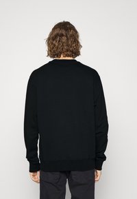 Svart sweatshirt med långa ärmar, rund halsringning och ribbade mudd. Slät textur, minimalistisk design och inga synliga mönster eller logotyper.