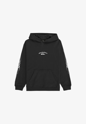 Czarna bluza z kapturem z logo z przodu, długie rękawy z białymi grafikami, zestawiona z zielonymi luźnymi dżinsami i czarnymi sneakersami.