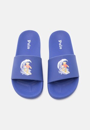 Μπλε σανδάλια με λουράκια που έχουν γραφικό από αρκούδα σέρφερ και την επιγραφή "Polo" στη σόλα.