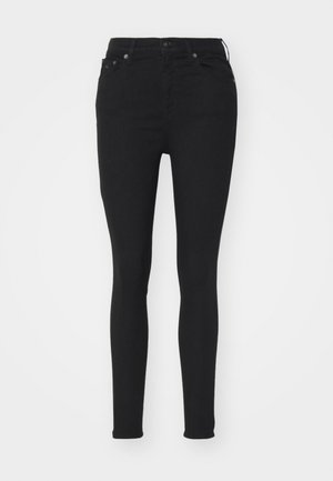 Zwarte high-waisted skinny jeans met voor- en achterzakken, knoopsluiting en een aansluitende snit op een witte achtergrond.