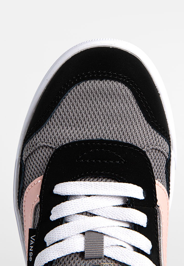 Zapatilla negra y gris con materiales de malla y ante, cordones blancos, acentos rosas y una superficie texturizada. Presenta una marca en el lateral.