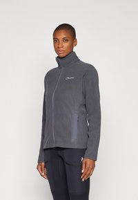 Gray fleece jacket with a high collar, front zipper, and side pockets. Features a subtle logo on the chest and smooth texture.
