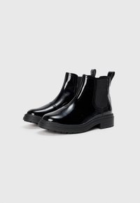 Svarte lakkleather Chelsea-boots med elastiske sidepaneler og trekkremmer, med en tykk svart gummisåle for godt grep.