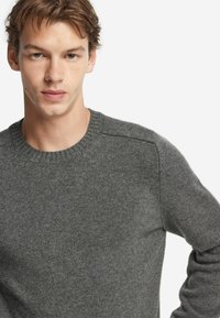 Dunkelgrauer gestrickter Pullover mit rundem Halsausschnitt, langen Ärmeln und gerippten Bündchen. Glatte Textur mit sanften Farbvariationen.