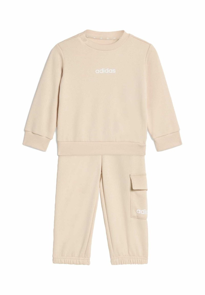 Beżowy zestaw składający się z bawełnianej bluzy i spodni. Bluza ma okrągły dekolt i ściągacze na rękawach; spodnie mają kieszeń typu cargo i elastyczne mankiety.