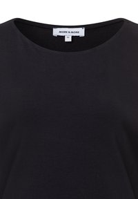 Zwarte ronde hals t-shirt gemaakt van zachte stof, met een eenvoudig ontwerp en een label waarop de merknaam "MORE & MORE" en maat 36 staat.