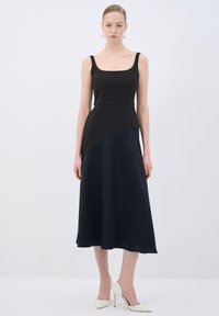 Schwarz und marineblaues zweifarbiges Kleid mit Quadrat-Ausschnitt, tailliertem Oberteil und weit schwingendem Midi-Rock. Glattes Material und subtile Nahtdetails.