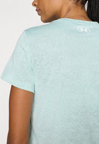 Ανοιχτό μπλε μπλουζάκι με διακριτό υφασμάτινο μοτίβο, κοντά μανίκια και μικρό λογότυπο στο πίσω μέρος του λαιμού. Απαλό ύφα σμα, άνετη εφαρμογή.