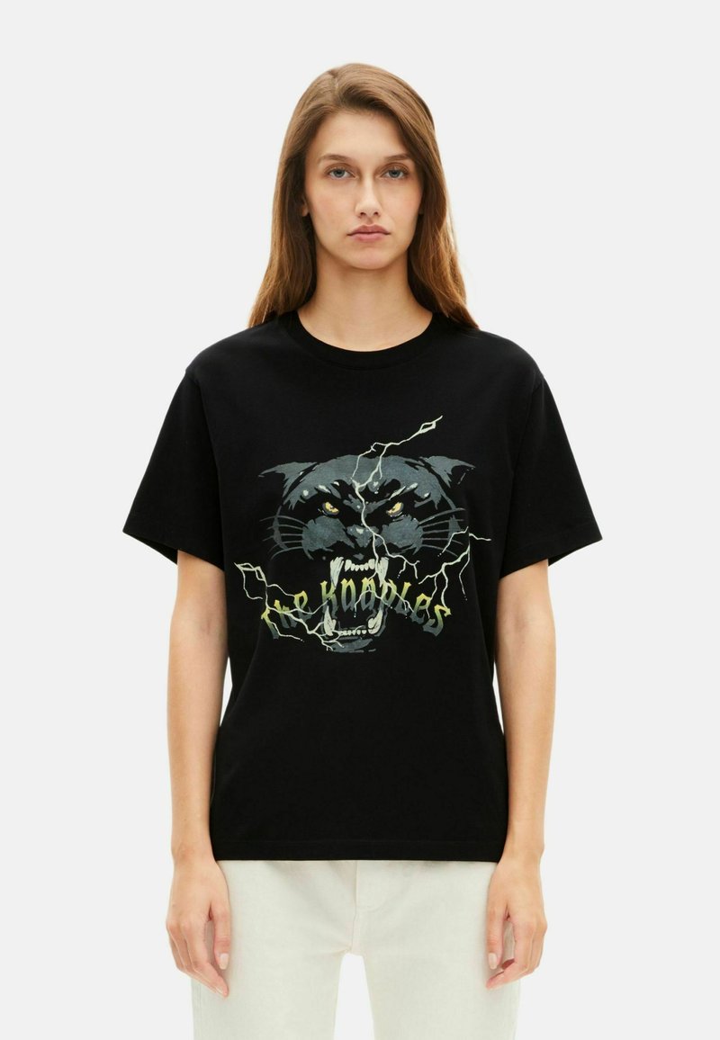 Svart t-skjorte i bomull med et grafisk design av et panteransikt, med lyse gule øyne og lyn-akenter i lys grønn.