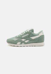 Green suede and mesh athletic sneaker with white accents, round toe, lace-up closure, and padded collar. Reebok logo featured on the tongue.