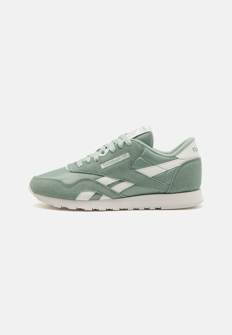 Green suede and mesh athletic sneaker with white accents, round toe, lace-up closure, and padded collar. Reebok logo featured on the tongue.