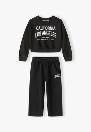 Fekete, hosszú ujjú, rövidített pulóverből és gumis derekú nadrágból álló két részes szett, fehér "California Los Angeles" felirattal a felsőn és a nadrágon.