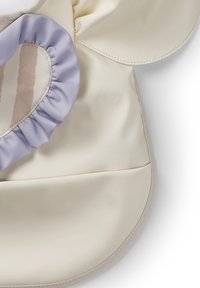 Beige accessory med en blød, skinnende finish, med et lavendelfarvet flæseaccent og et stribet mønster i bløde toner.